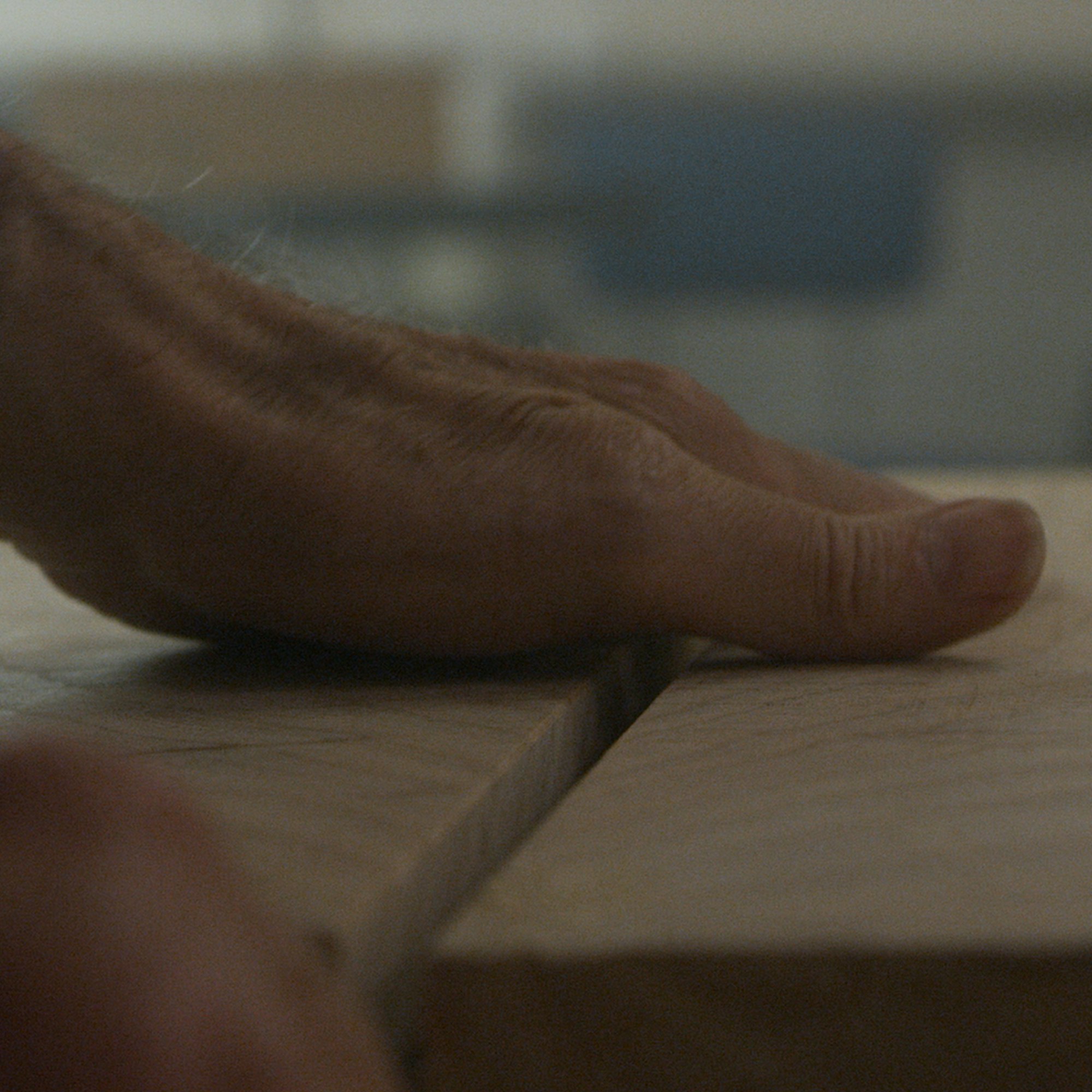 A man's hands on a wooden surface